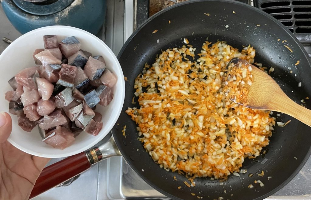 玉ねぎの色が変わってきたら、サイコロ状に切ったサバを加える