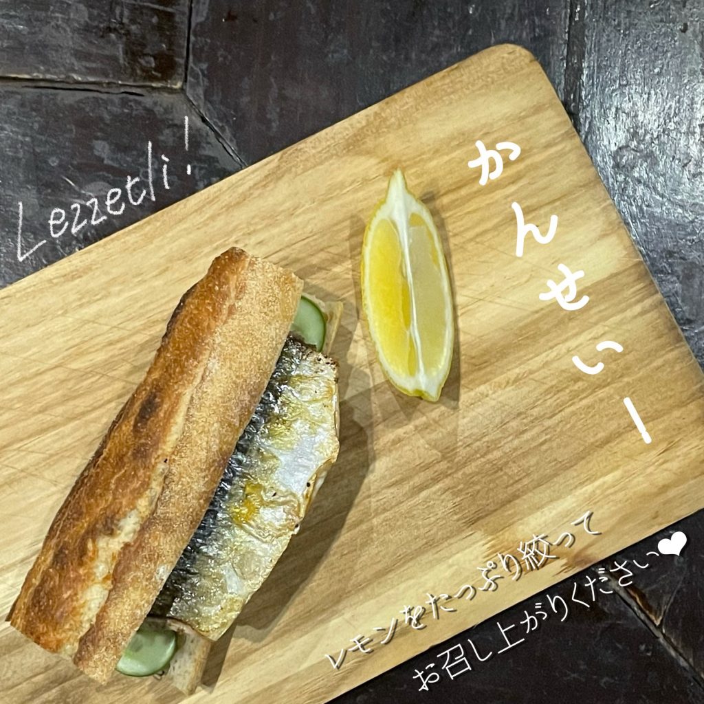 バゲットをトースターで1分ほど焼き水を切った玉ねぎと焼いたサバを挟み、レモンを絞って完成